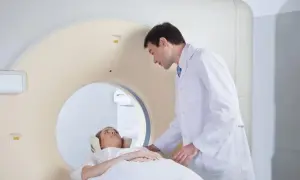 Lekarz pomaga pacjentce ułożyć się do badania rezonansem z kontrastem. Przygotowanie do procedury jest kluczowe.