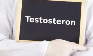 Lekarz w białym fartuchu i rękawiczkach wskazuje na tabliczkę z napisem "Testosteron". Temat: niski testosteron u kobiet.