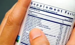 Palec wskazuje na etykietę "Supplement Facts", wyjaśniając, co to jest suplement diety i jakie składniki zawiera.