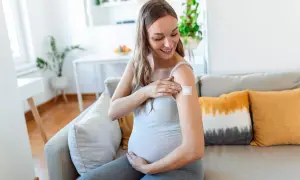 Kobieta w ciąży z plastrem na ramieniu po szczepieniu. Dba o zdrowie swoje i dziecka, chroniąc się przed RSV.