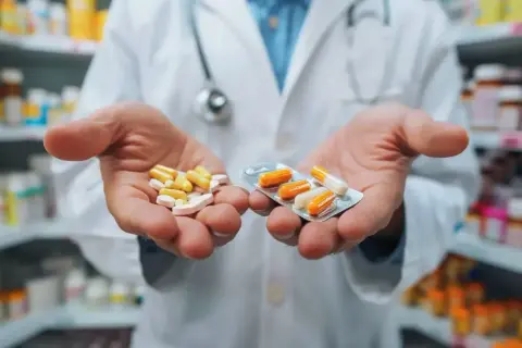 Farmaceuta prezentuje suplement i lek w kapsułkach. Wybór między nimi zależy od potrzeb.