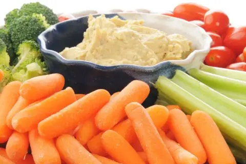 Co to jest hummus? Kremowy dip z ciecierzycy, podany z chrupiącymi marchewkami, selerem, brokułami i pomidorkami koktajlowymi.