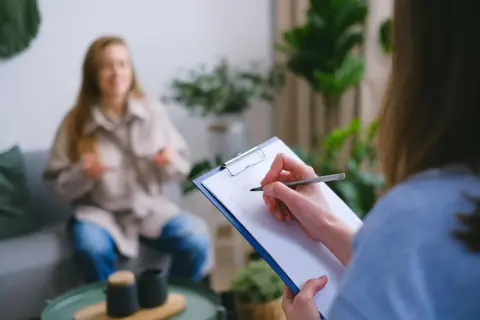 Superwizja dla psychologa: jedna osoba notuje, druga siedzi na kanapie.
