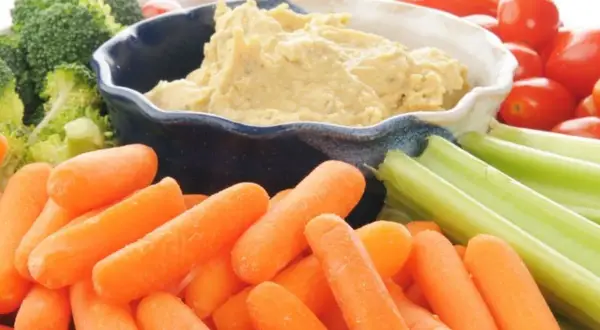 Co to jest hummus? Kremowy dip z ciecierzycy, podany z chrupiącymi marchewkami, selerem, brokułami i pomidorkami koktajlowymi.