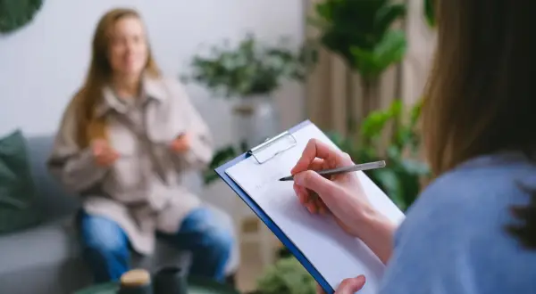 Superwizja dla psychologa: jedna osoba notuje, druga siedzi na kanapie.