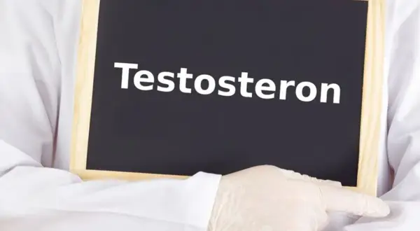Lekarz w białym fartuchu i rękawiczkach wskazuje na tabliczkę z napisem "Testosteron". Temat: niski testosteron u kobiet.