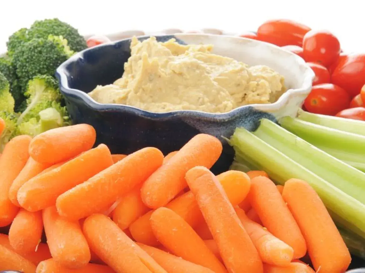 Co to jest hummus? Kremowy dip z ciecierzycy, podany z chrupiącymi marchewkami, selerem, brokułami i pomidorkami koktajlowymi.