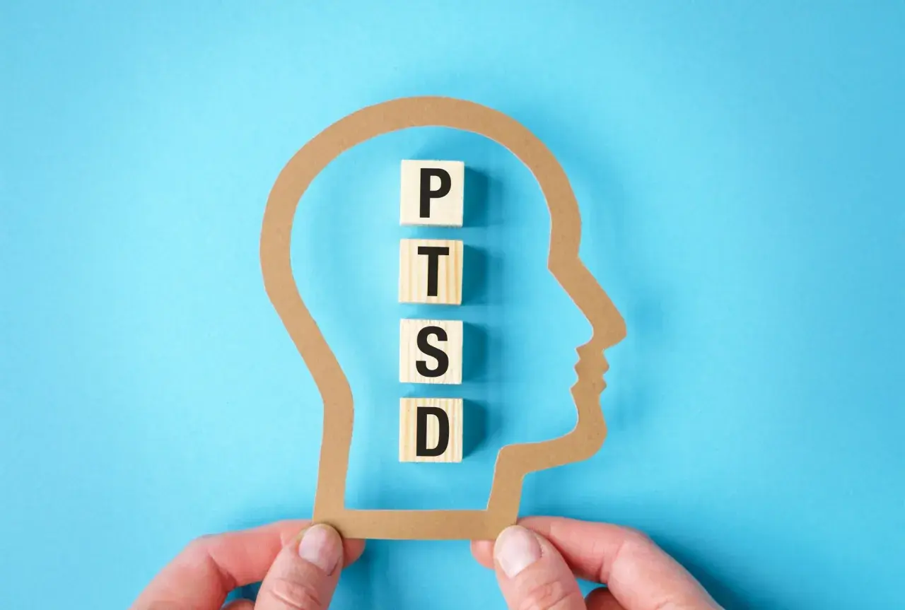 Klocki z literami P, T, S, D układają się w napis PTSD wewnątrz sylwetki głowy. Test na zespół stresu pourazowego.