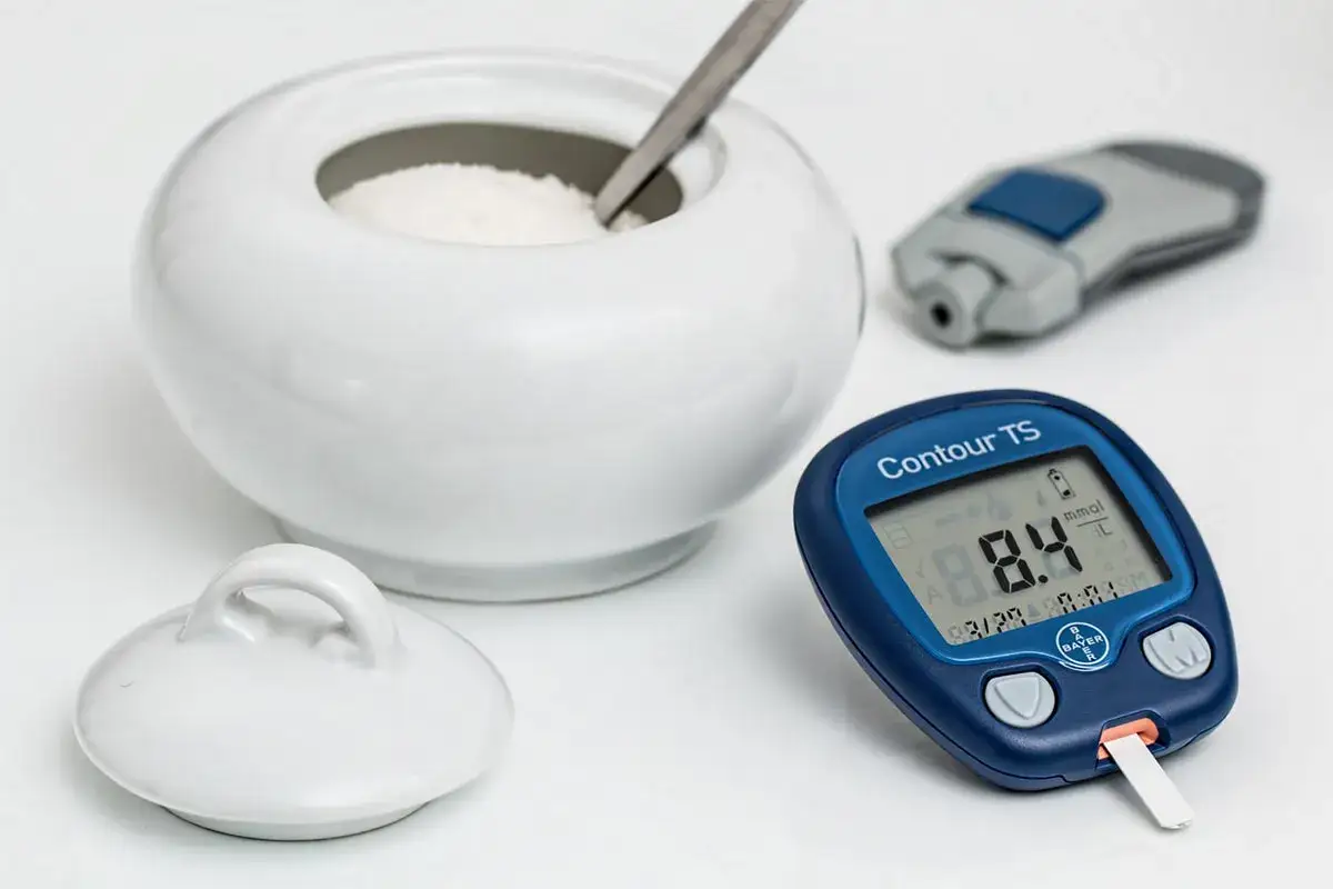 Glukometr pokazuje 8.4 mmol/L. Obok biała cukiernica i nakłuwacz. Pierwsze efekty po metforminie?