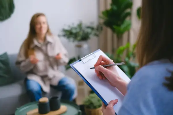 Superwizja dla psychologa: jedna osoba notuje, druga siedzi na kanapie.